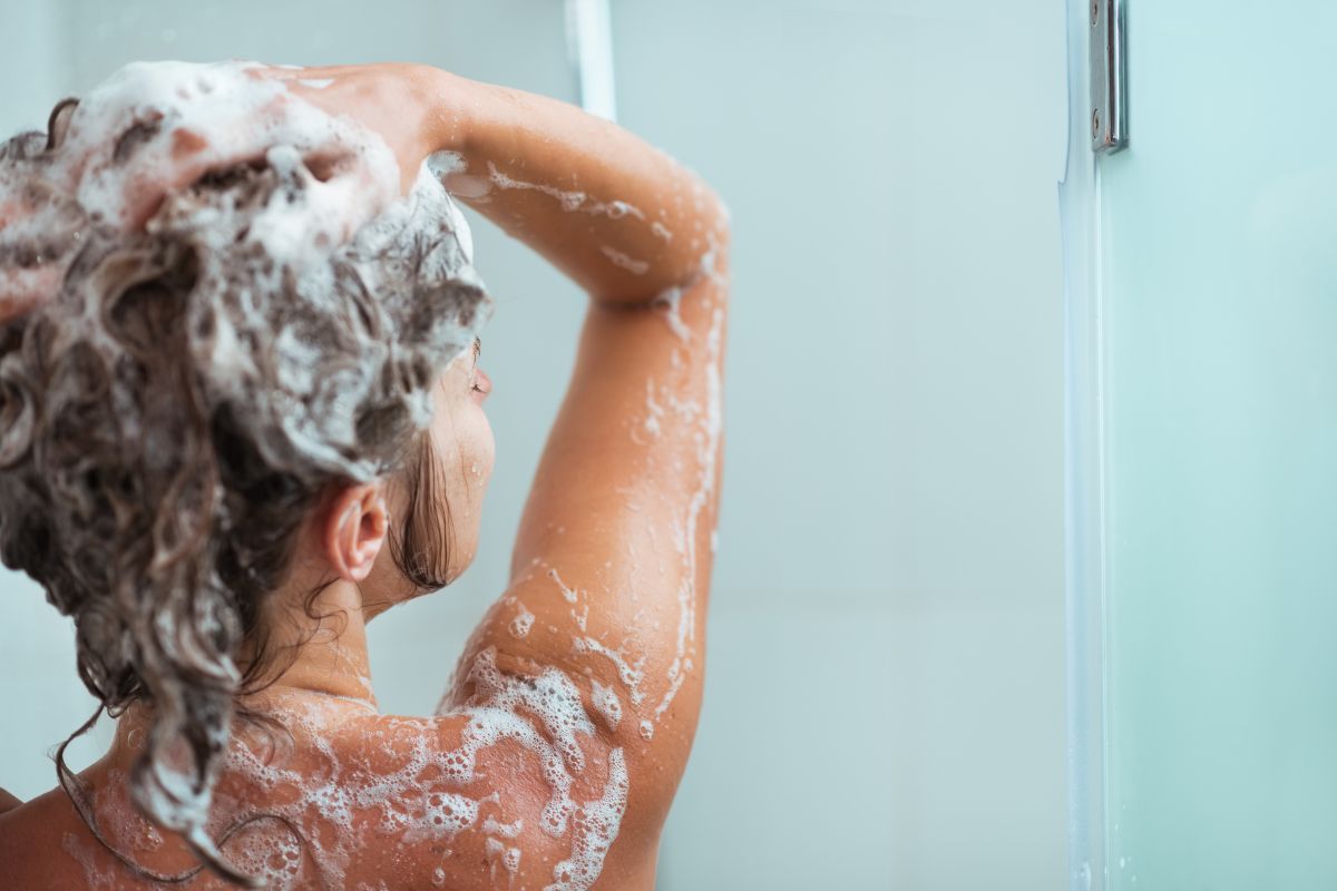 what shampoo should i use (1) A person in the shower using a high-quality shampoo in hair.
