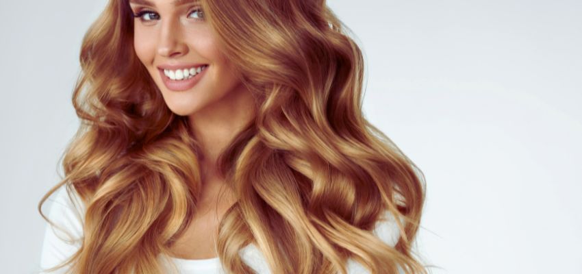 A woman is happy with her long, curly hair.