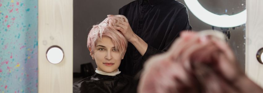 A woman is excited for her new look with a low-maintenance pixie cut for thin hair.